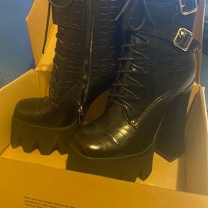 These are stylish platform boot that are black with a skin skin print
